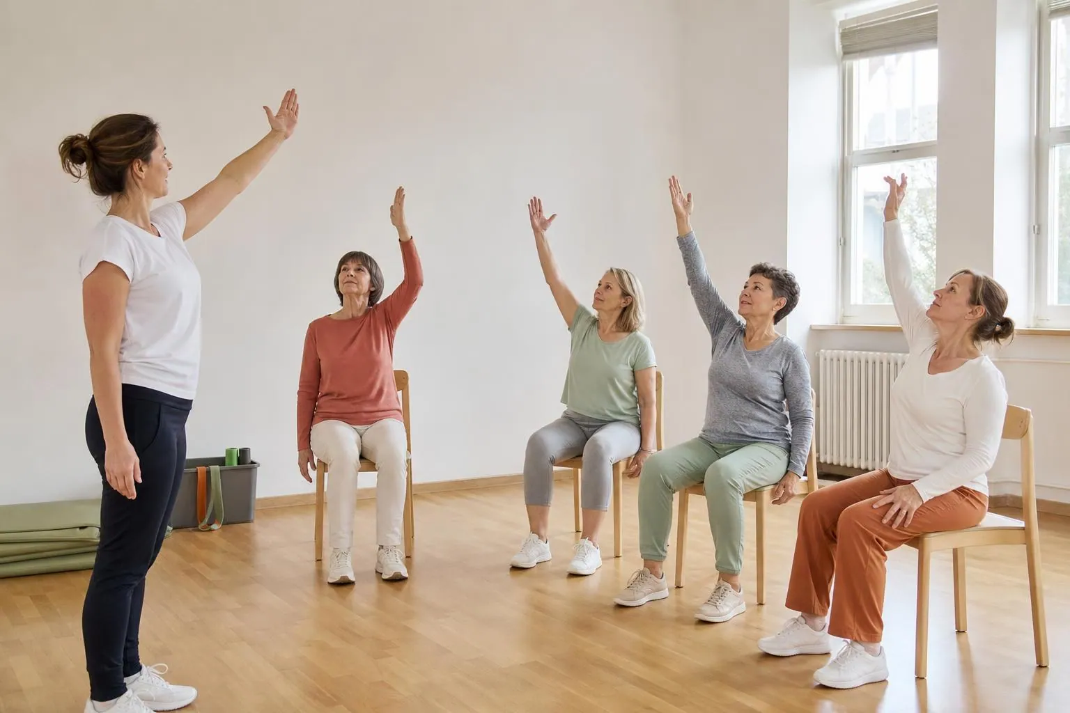 Petit groupe de femmes de cinquante à soixante ans assises en cercle sur des chaises dans une salle municipale claire, une éducatrice debout à côté d’elles